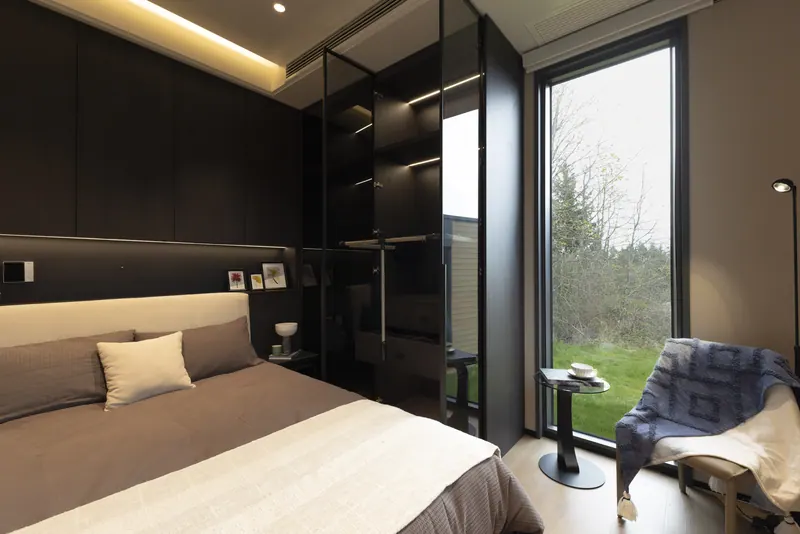 Ember bedroom with a reading chair at a floor-to-ceiling window