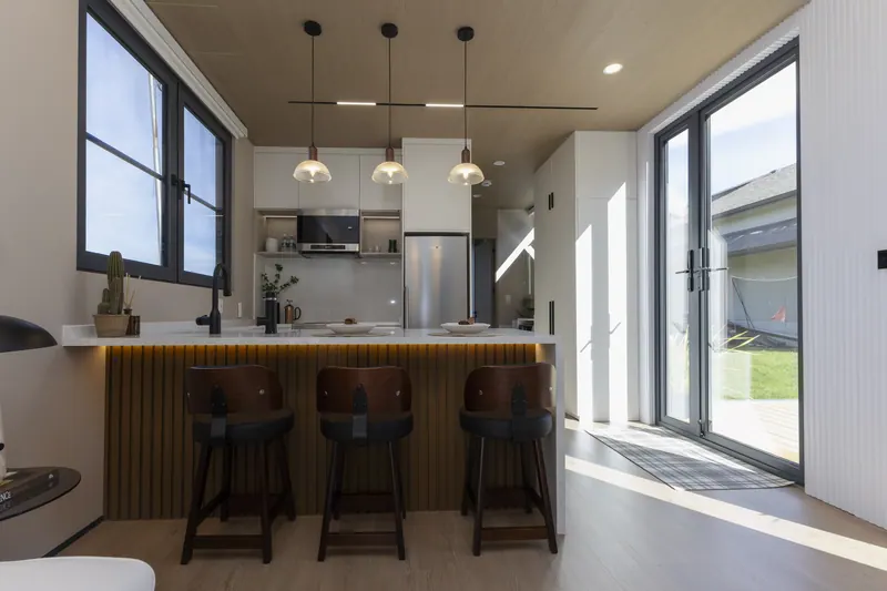 Quartz island with four stools seen from the living area