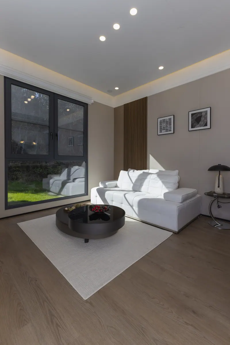Solace living area with a white sofa and tall windows