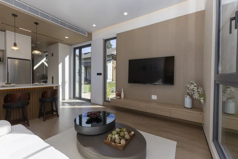 Solace living area with the oak TV wall and kitchen beyond