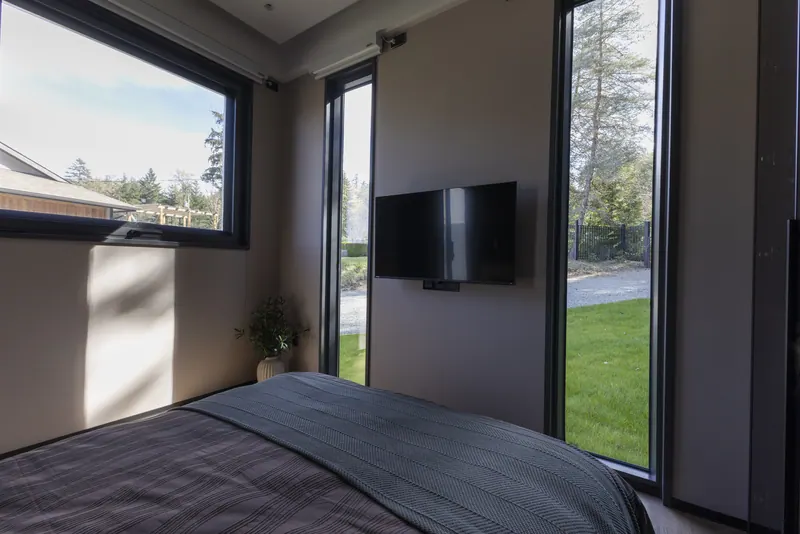 Bedroom looking toward two tall windows onto the lawn