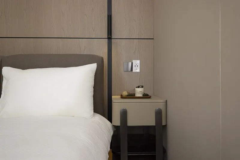 Bed and nightstand against an oak wall panel