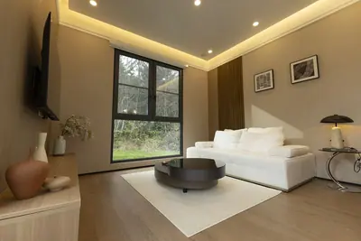 Living room with a tall ceiling and a floor-to-ceiling window
