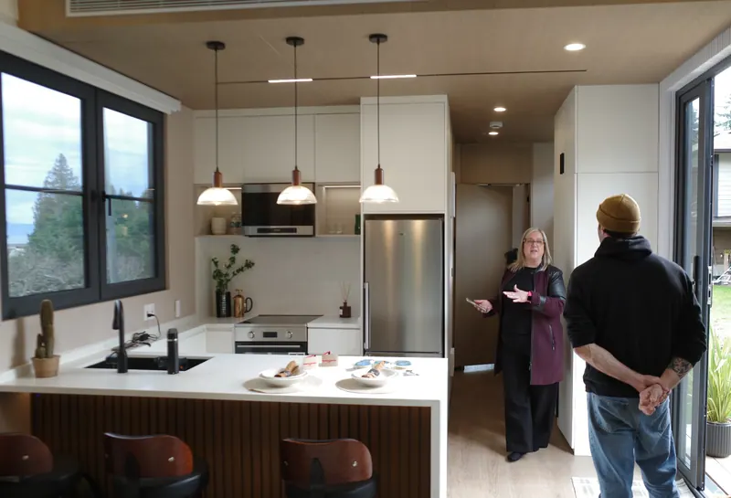 Two visitors talking in the kitchen of a Cueva show home
