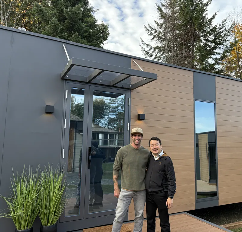 A Cueva team member and a visitor, arm in arm, in front of a show home