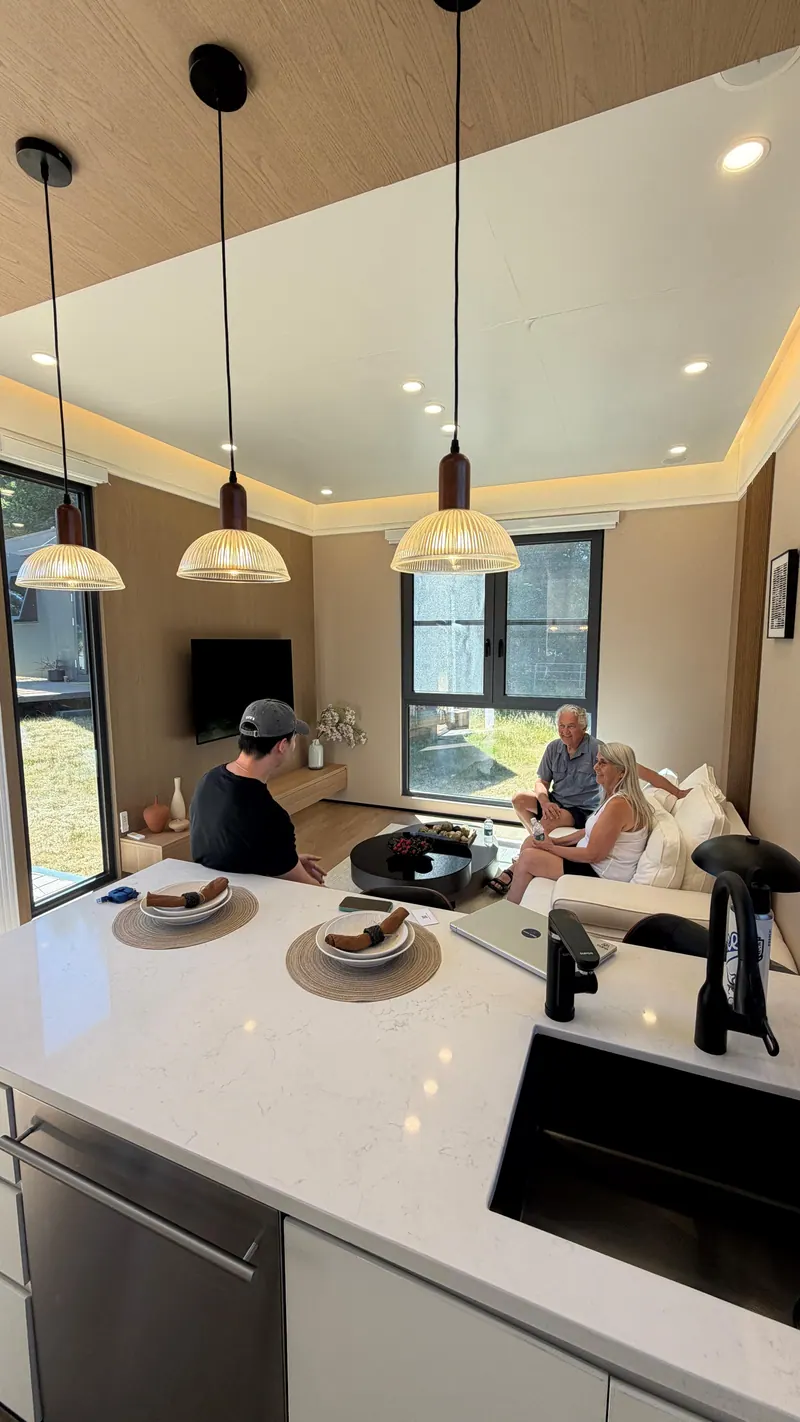 Visitors seated in the living area, seen from behind the kitchen counter