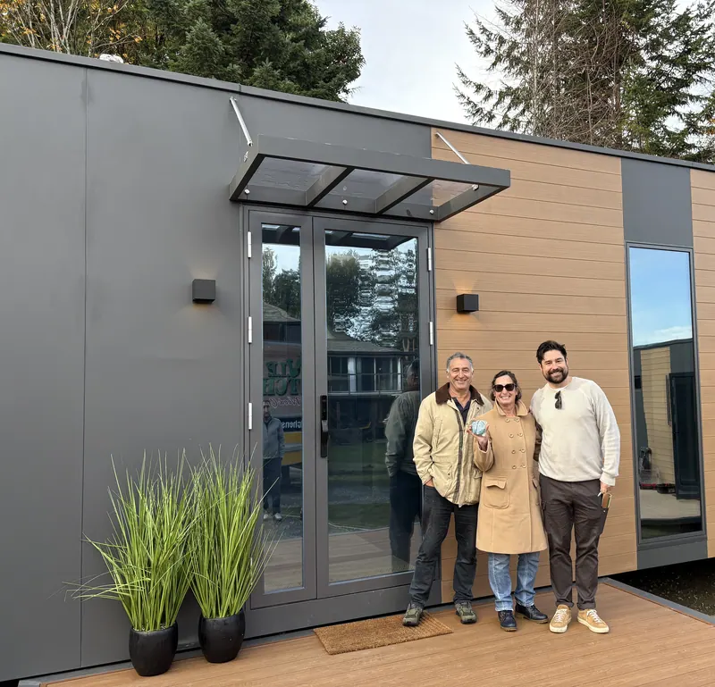 Three visitors at the front door of a show home in the fall