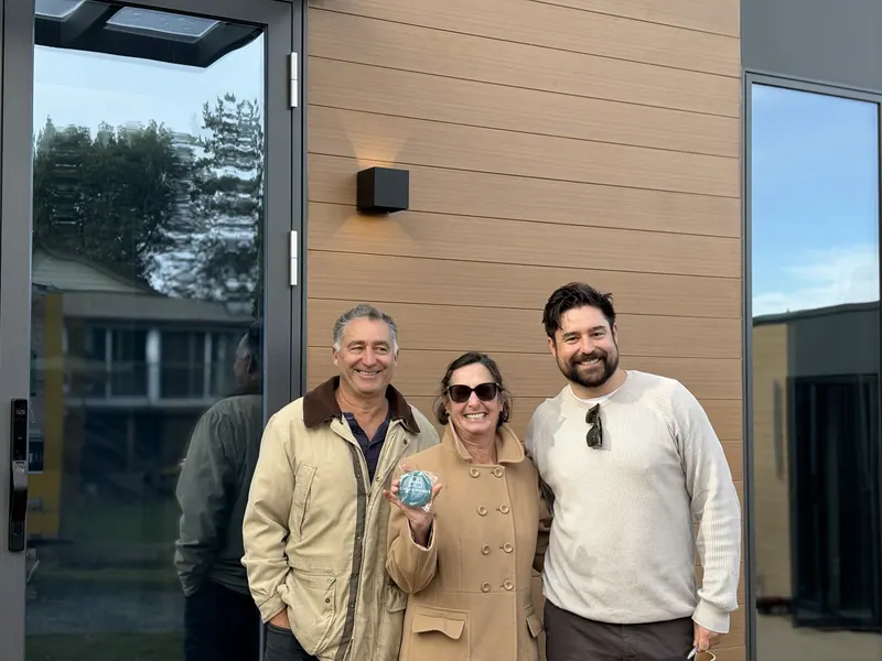 Three visitors laughing together outside a show home