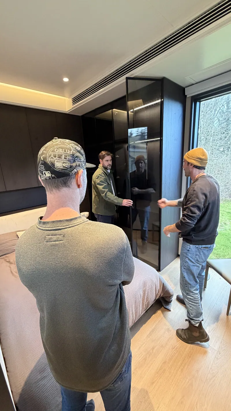 A visitor opening the lit glass-door wardrobe