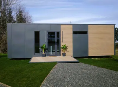 Front of a show home with planters and a gravel path